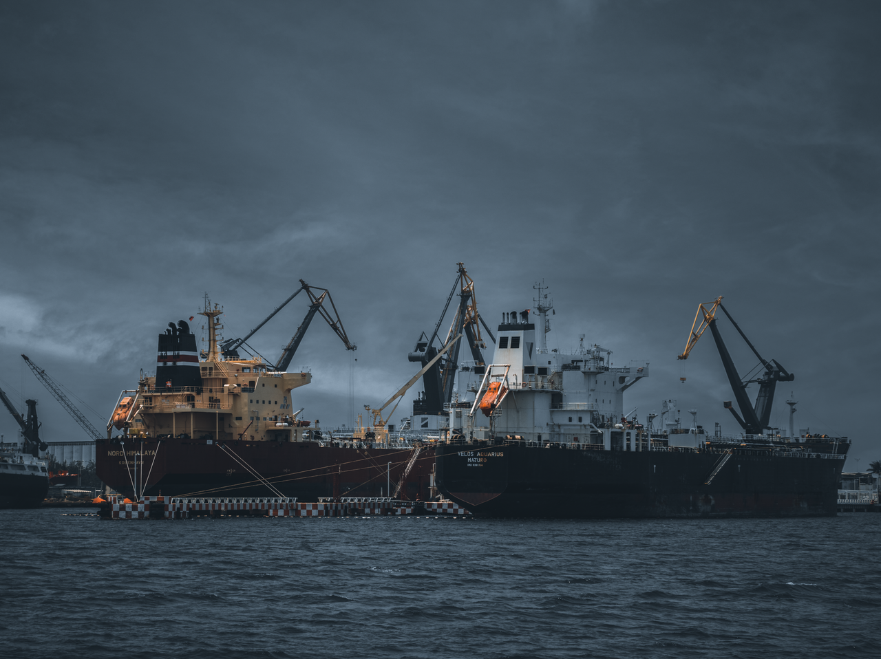 Crafting Captivating Headlines: Your awesome post title goes here Cargo ships at a bustling port under cloudy skies, cranes ready for loading.