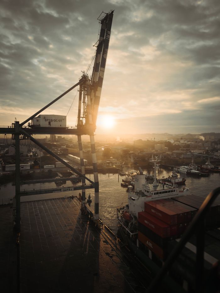 Crafting Captivating Headlines: Your awesome post title goes here A breathtaking sunset view over Bintulu Port, Sarawak, Malaysia, featuring a crane and cargo ships.